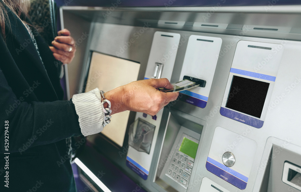 Midsection of woman inserting card in ATM machine